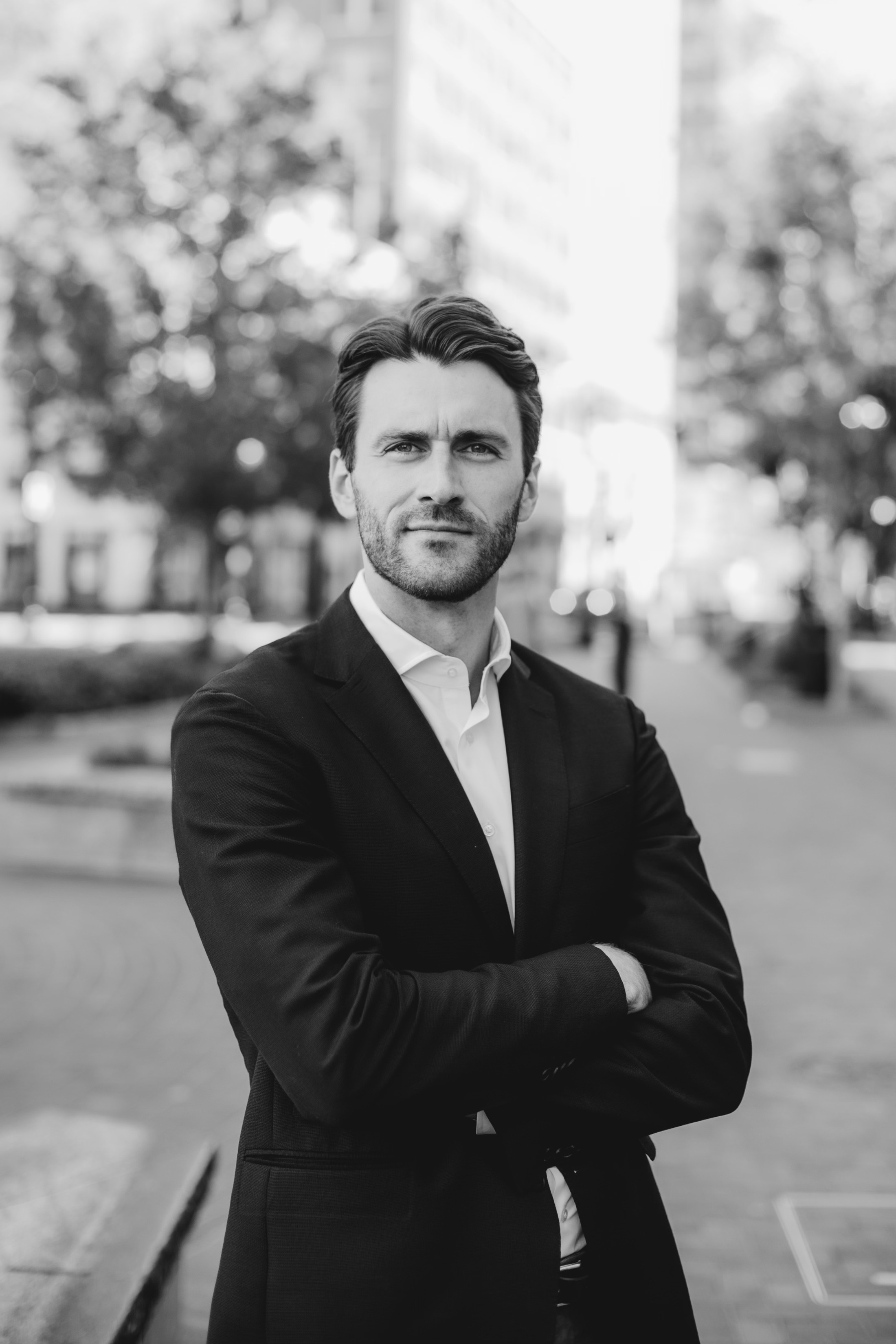 A black-and-white professional portrait of a man in a suit