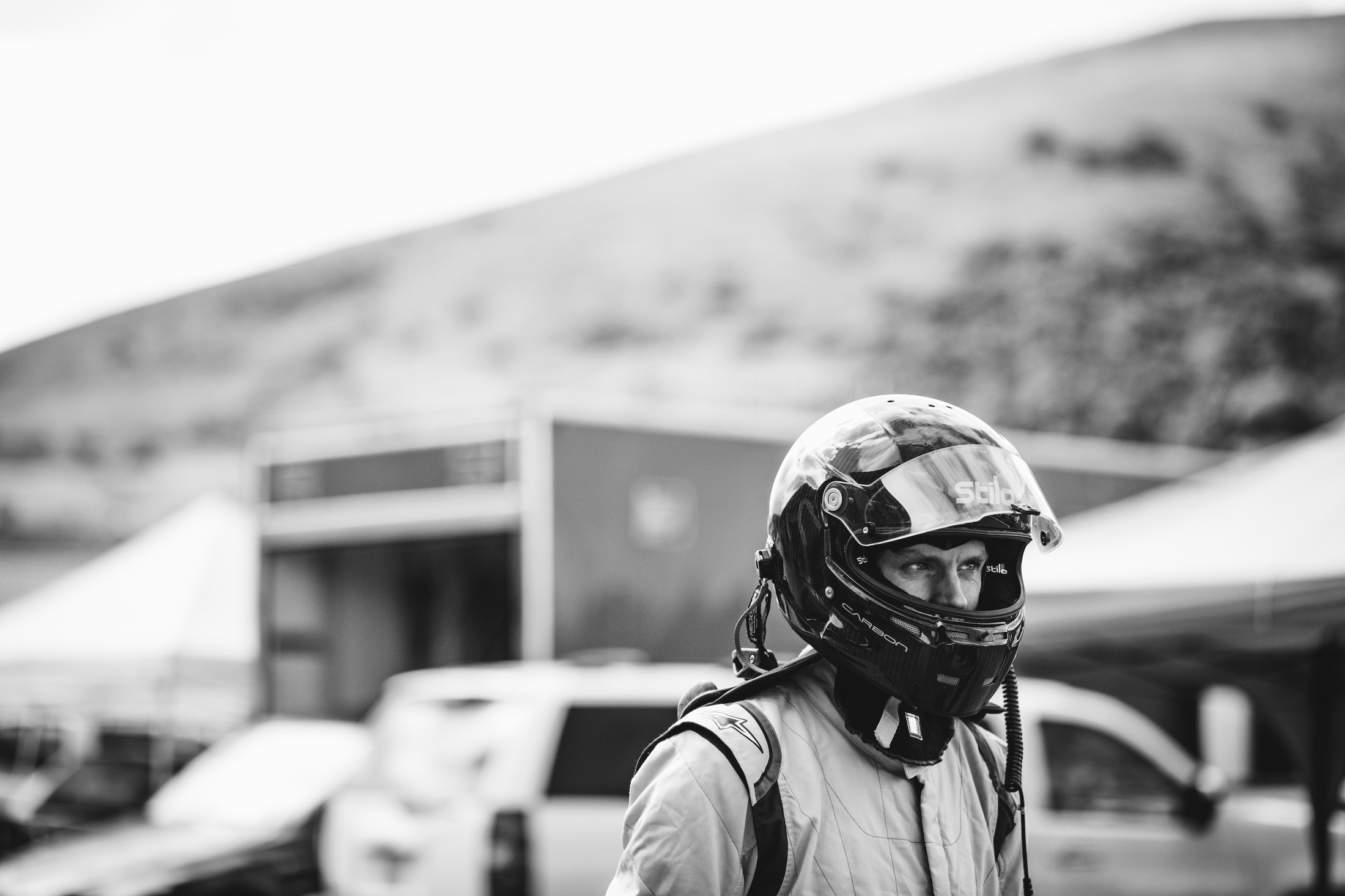 A race driver in a helmet photographed in black and white